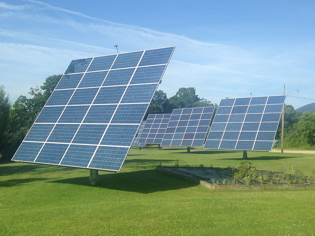 Solar cell arrays lined up in a field.