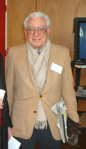 The image shows a picture of physicist Murray Gell Mann, who looks like a pleasant white-haired gentleman.